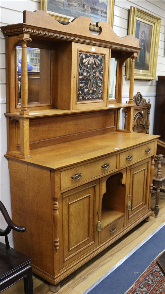 An Art Nouveau oak sideboard, the superstructure centred by a pierced copper fronted cupboard,.152cm W.152cm